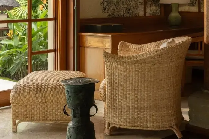 Inside a single-storey pavilion, rattan armchair and jar