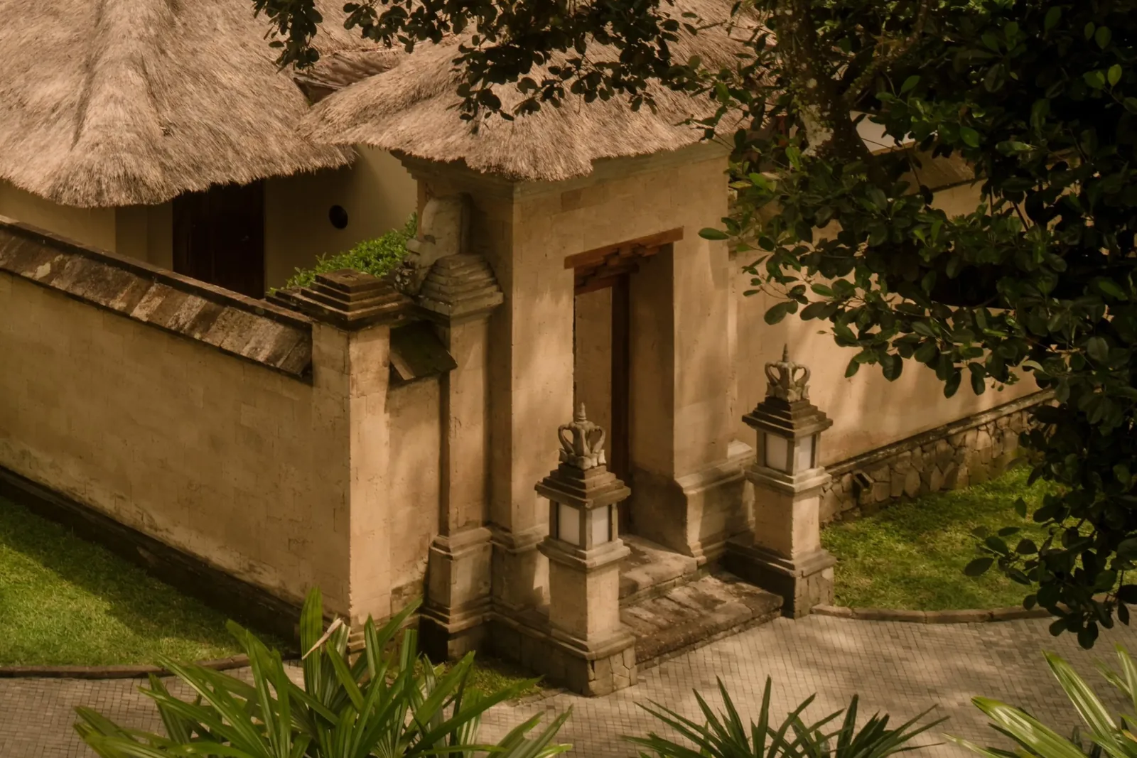 The entrance to a pavilion, stone walls and thatched roof