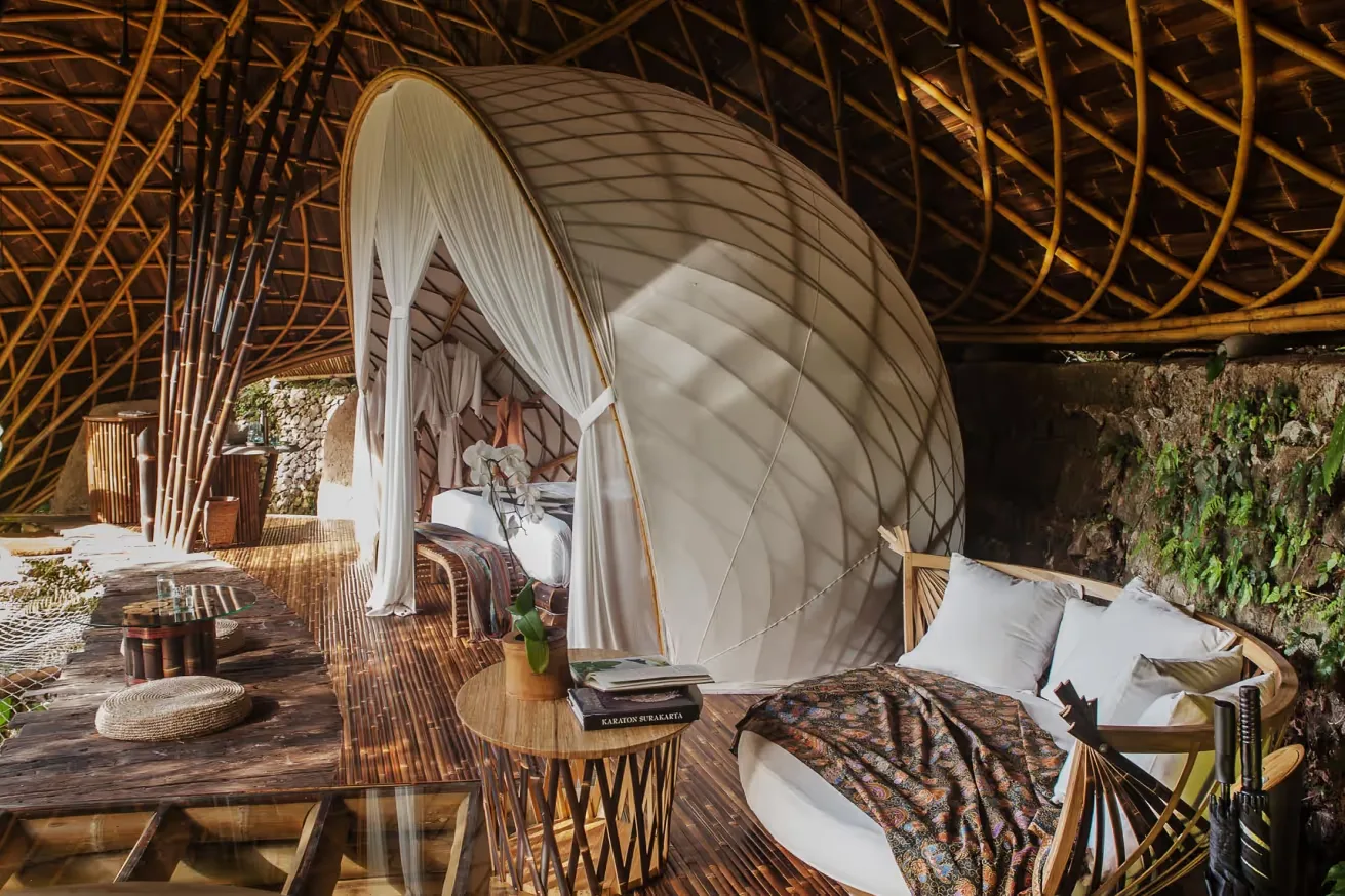 A bedroom under a bamboo roof structure
