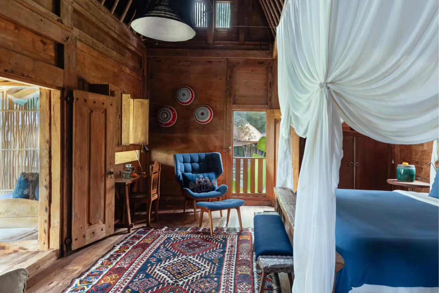 Inside an antique teak house, with a canopy bed