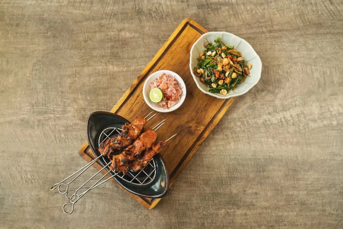 Sate babi merah skewers on their board