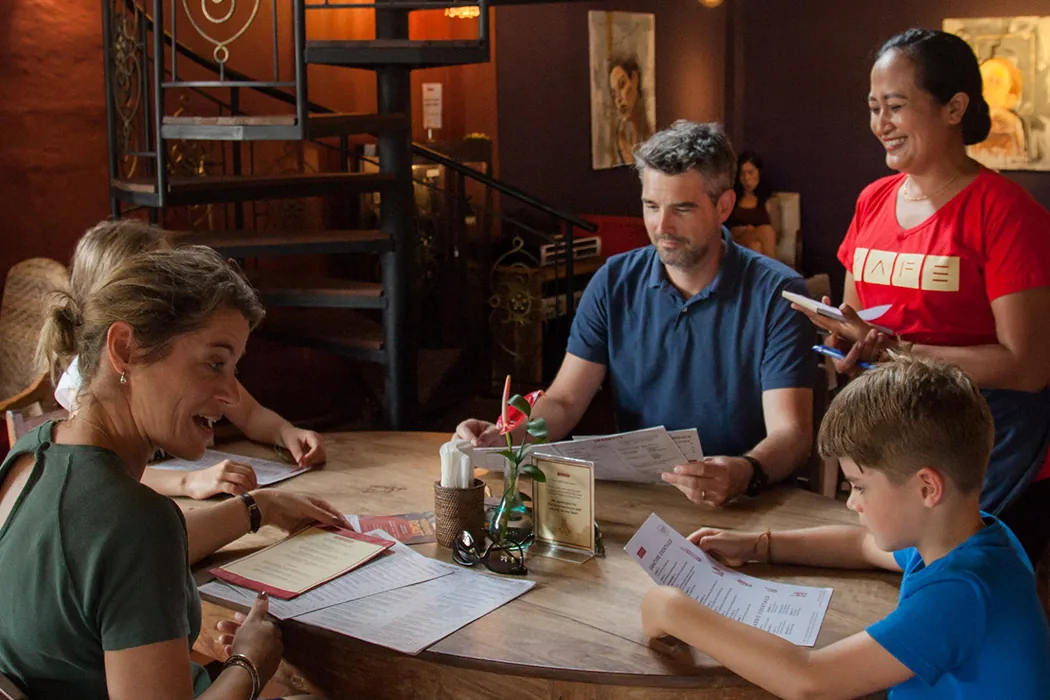 A family looks at the menu in the dining room