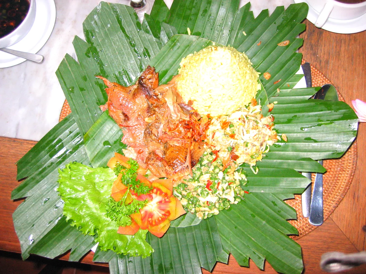 Betutu served on a banana leaf, with turmeric rice, vegetables and sauce