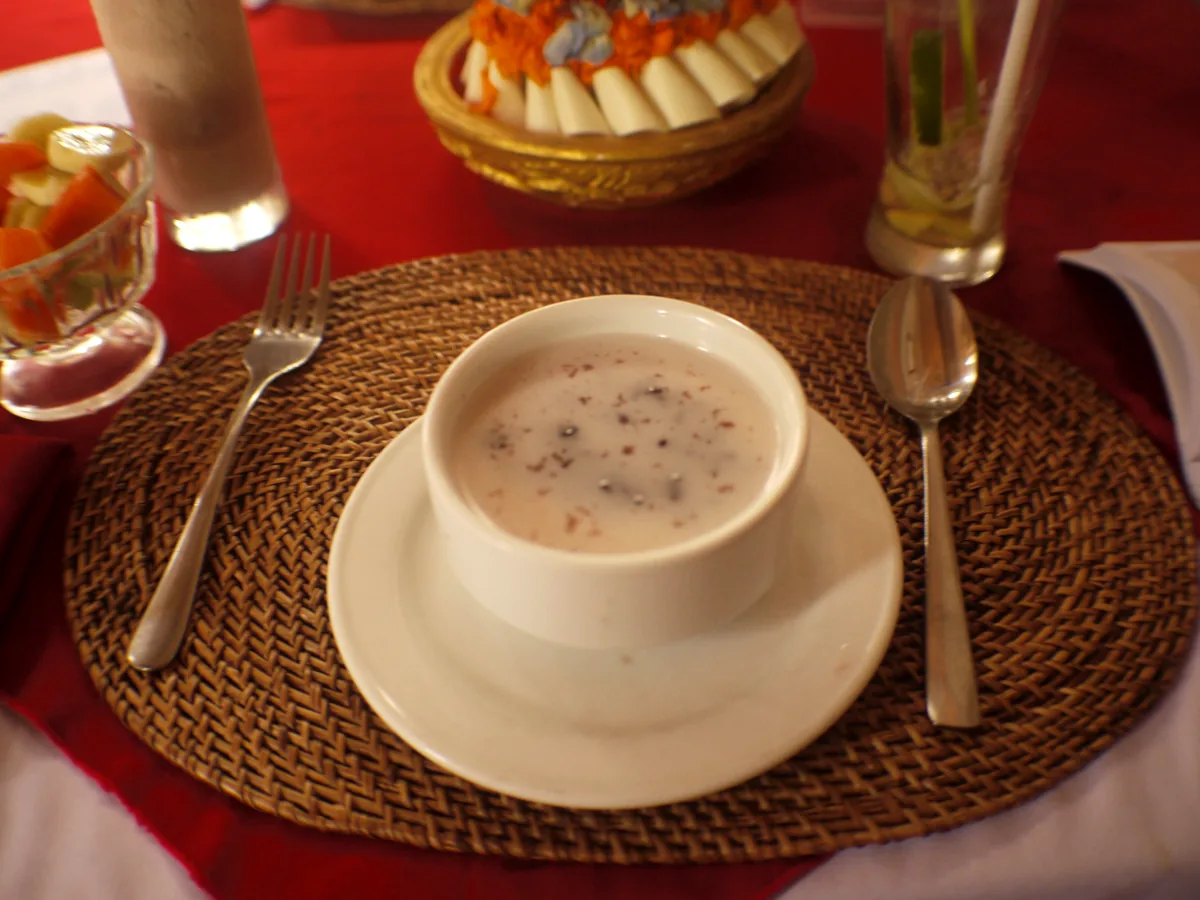 Bowl of black glutinous rice topped with a swirl of coconut milk