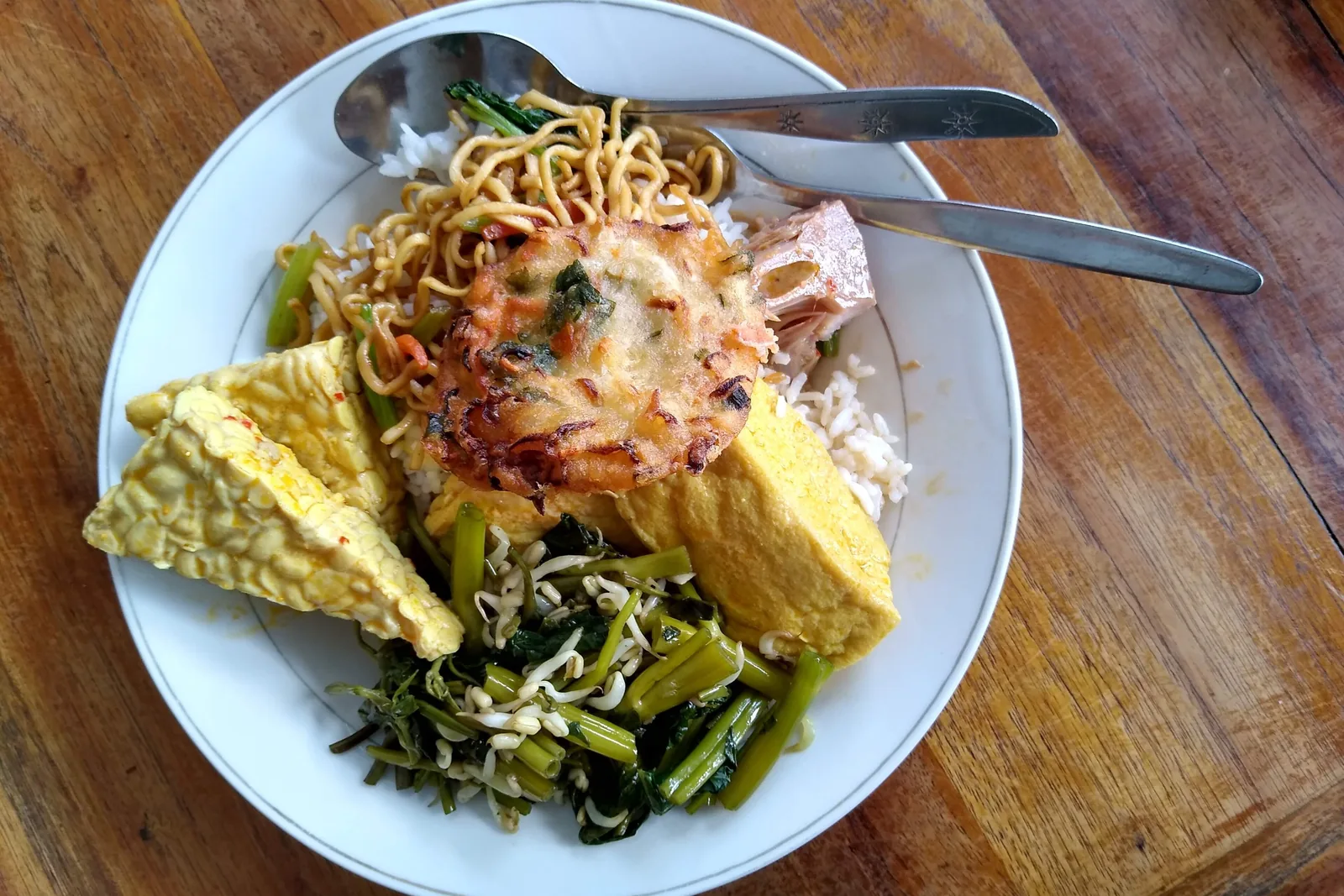 Warung plate: noodles, vegetable fritter, jackfruit, rice, tofu, water spinach and tempeh
